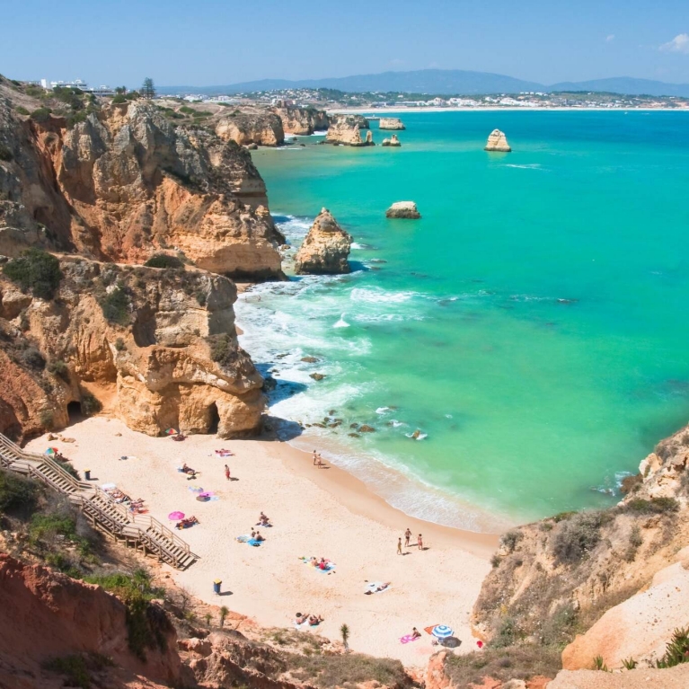 A sandy beach, surrounded by high cliffs