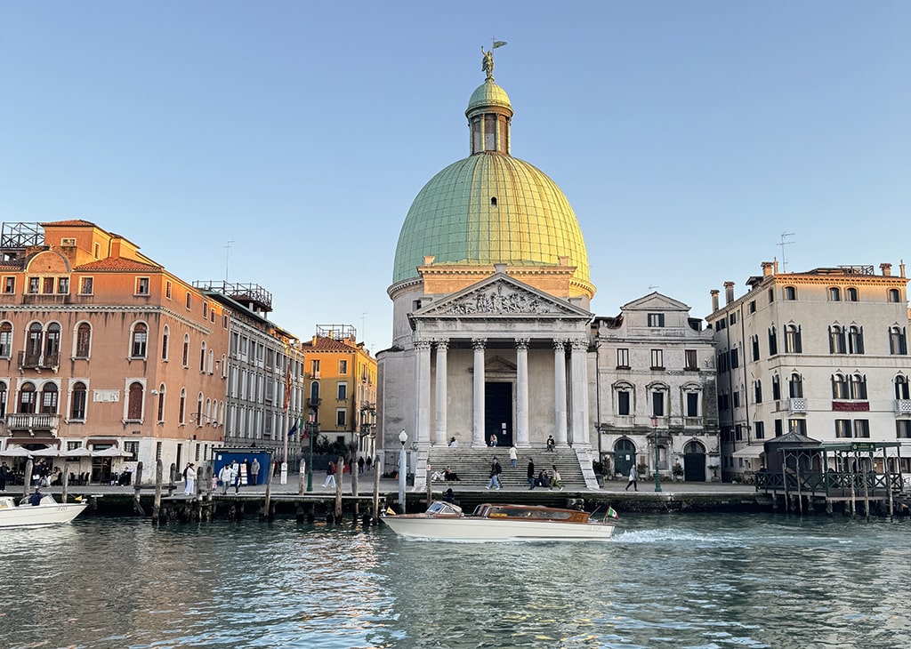 Historic buildings along a canal in Venice, bathed in the light of sunset 