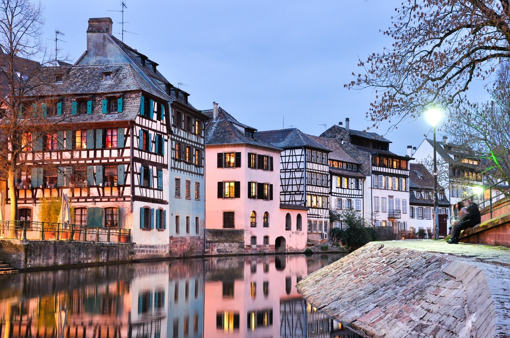 A twilight view of Petite-France's colourful, half-timbered houses alongside a canal