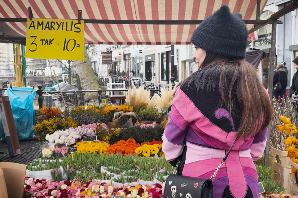 Mariana, a Utrecht local, admiring flowers at an outdoor market