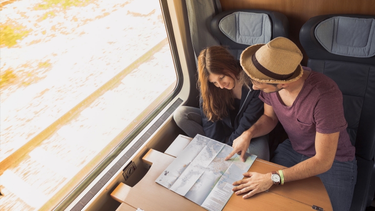 couple-travelling-on-train-next-destination