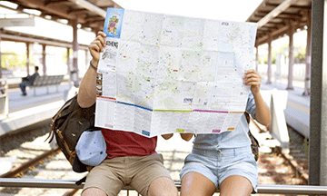 couple-looking-at-a-map-at-the-station-athens