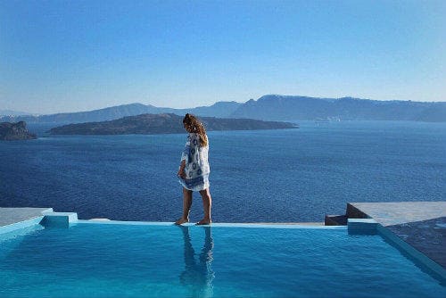 Todo acerca de Eurail | Niña caminando al costado de una piscina en Santorini, Grecia