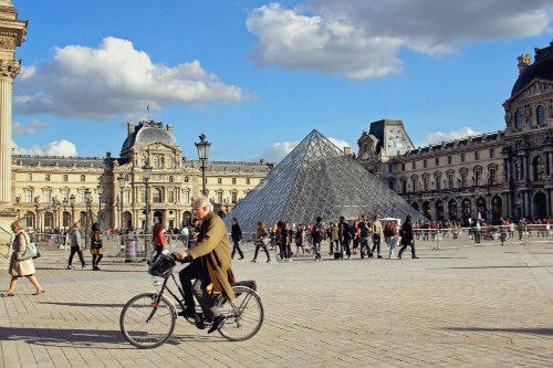old_man_on_the_bicycle_passing_by_in_front_of_the_pyramid_at_the_louvre_museum_paris_france_resized