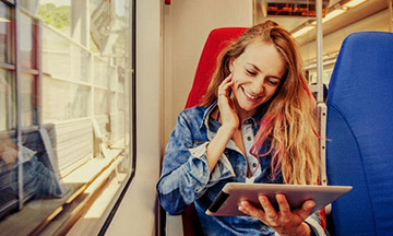 girl-on-train-with-tablet-smiling
