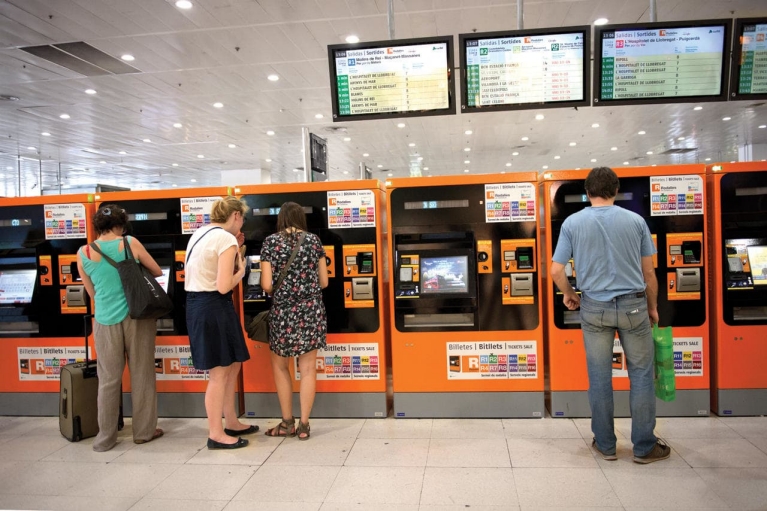 people_buying_tickets_at_barcelona_train_station