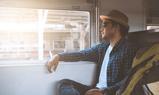 man-sitting-in-train-looking-out-window