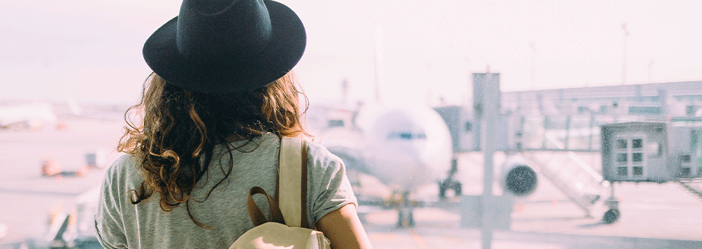 girl-at-airport-looking-at-airplane