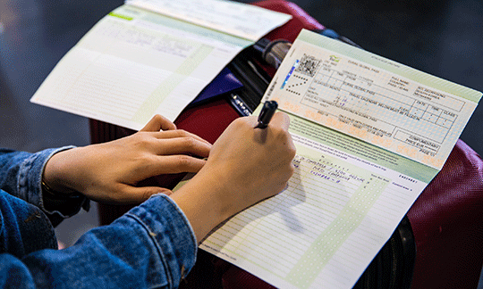 person-writing-in-travel-diary-on-station