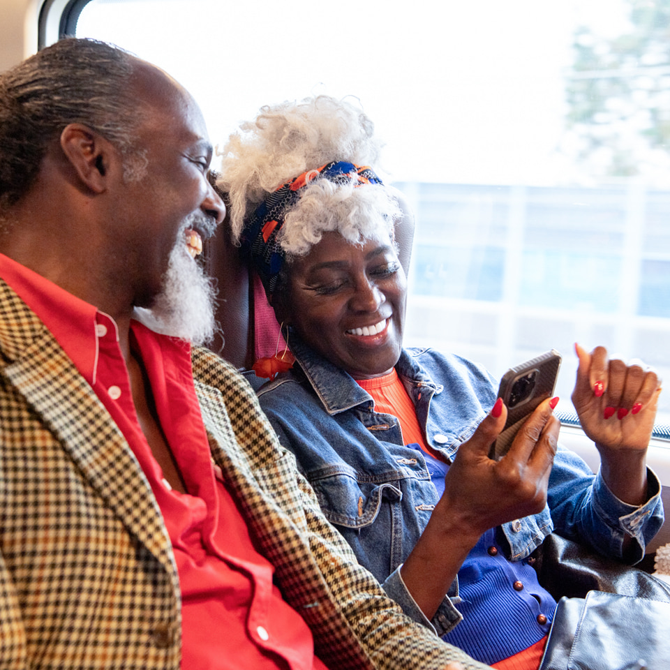 An older couple sitting inside a train