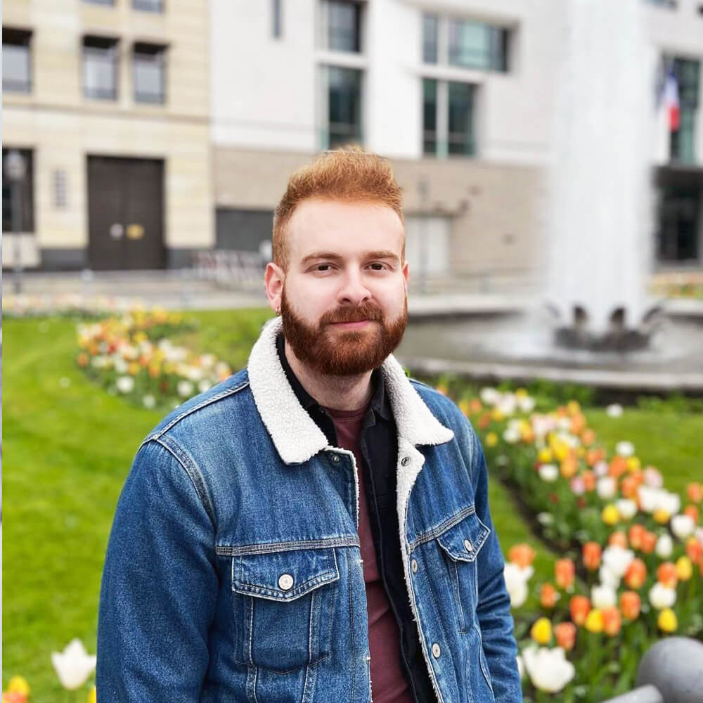 Photo of Eurail employee taken in front of a flower garden