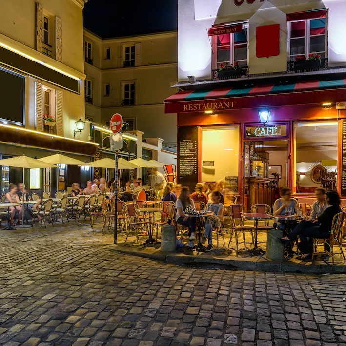 Una «brasserie» bajo el resplandor de las luces de la calle