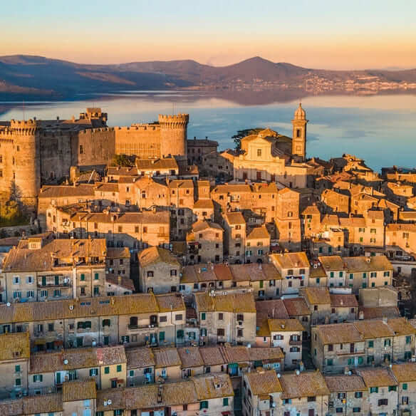 Vista aérea de Bracciano ao entardecer, com um lago ao fundo